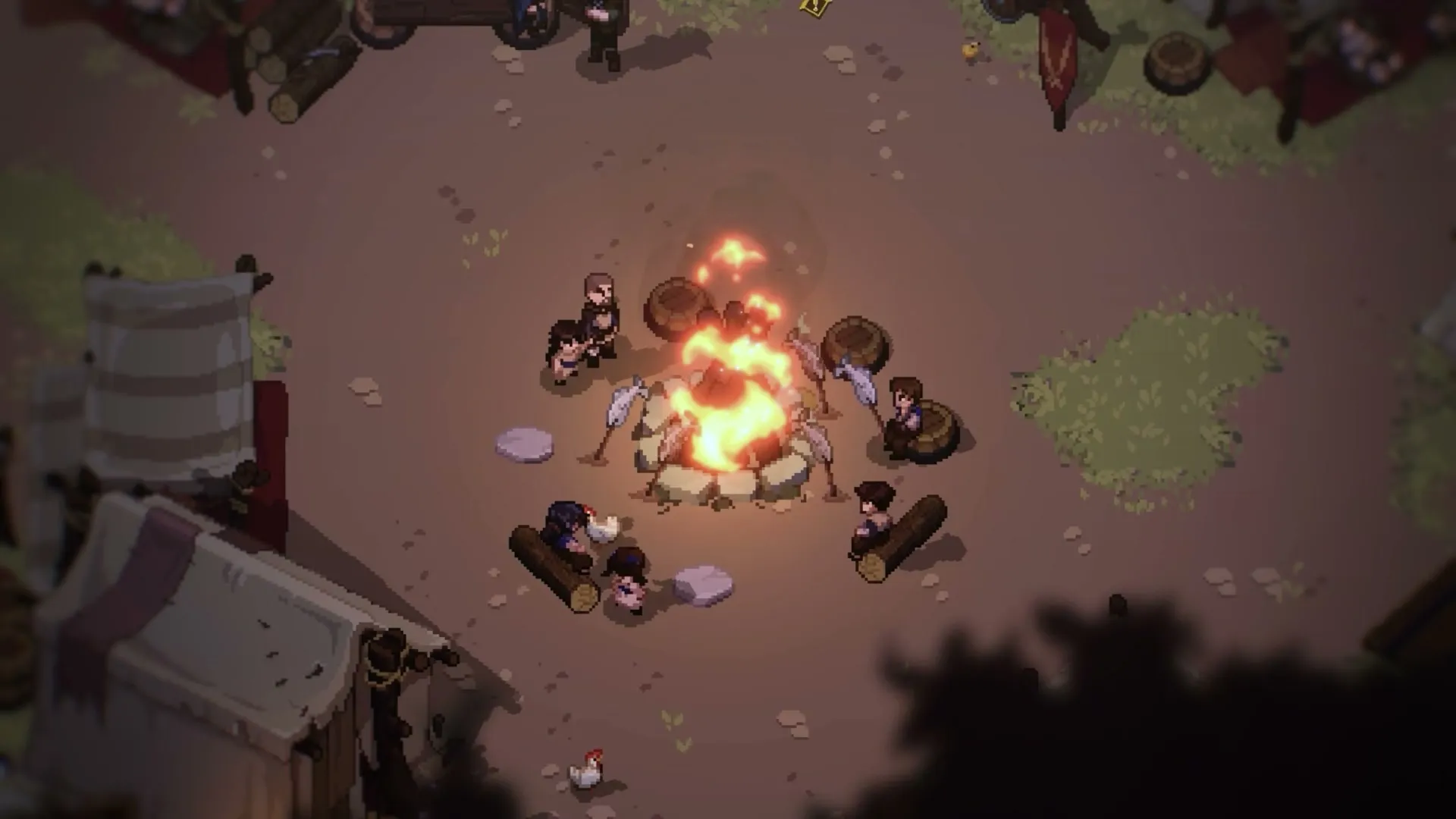 Villagers sitting around a large campfire between tents