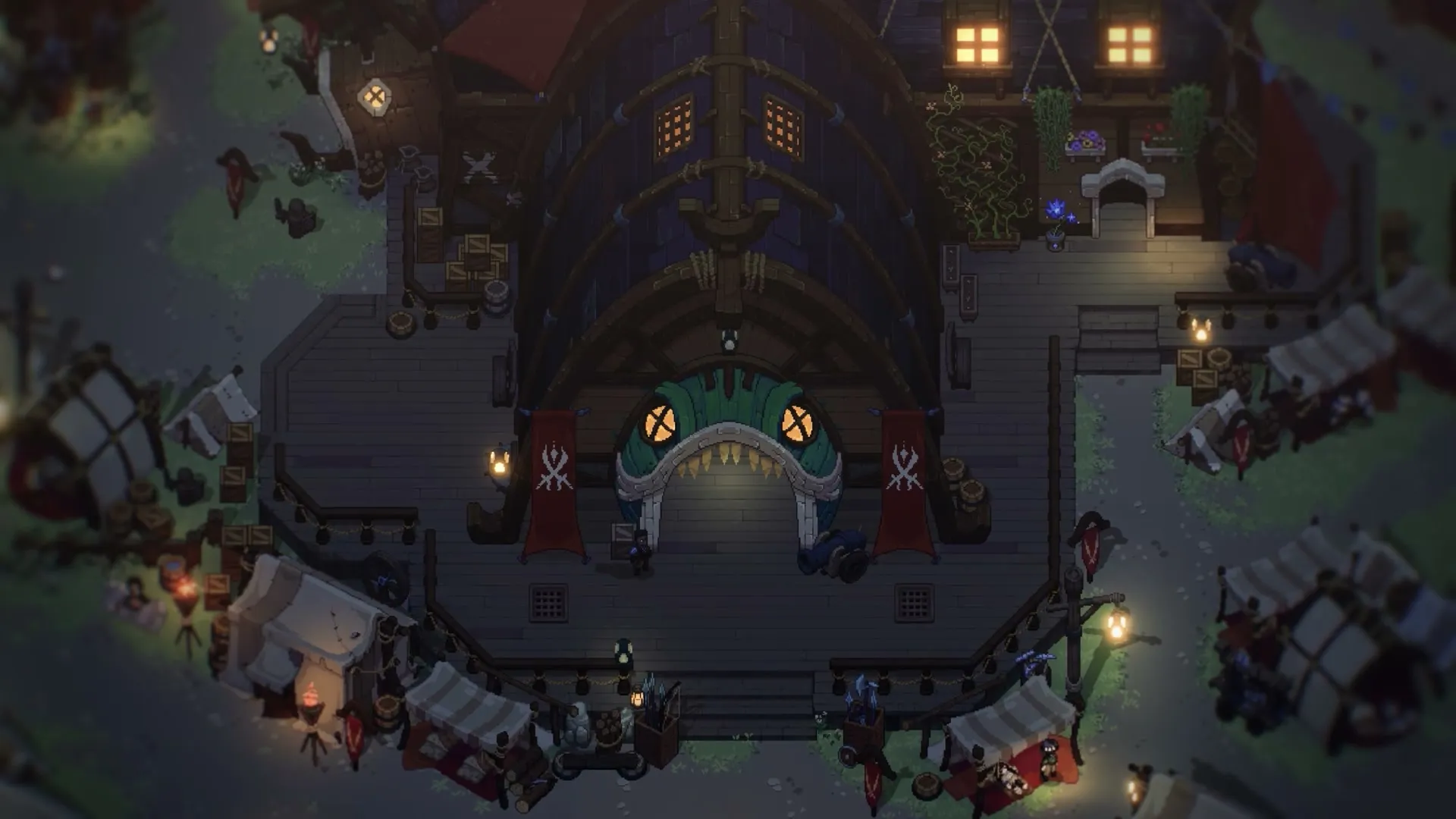 A large wooden hall with red banners at night, with stalls around the square